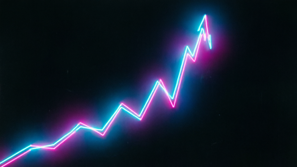 neon chart line spiking upward on a dark trading terminal