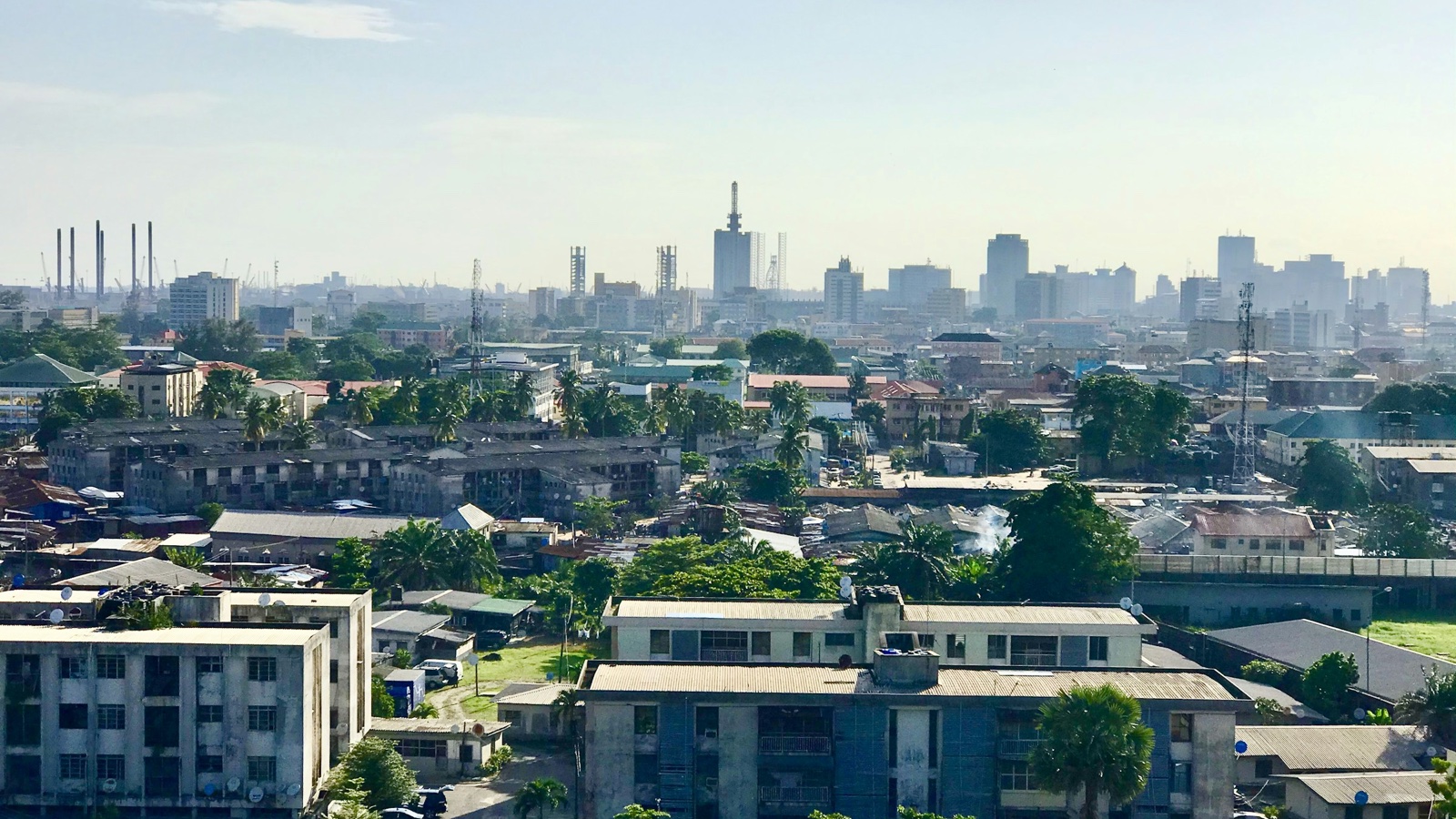 Hazy morning view over Lagos rooftops and apartment blocks toward the downtown skyline.