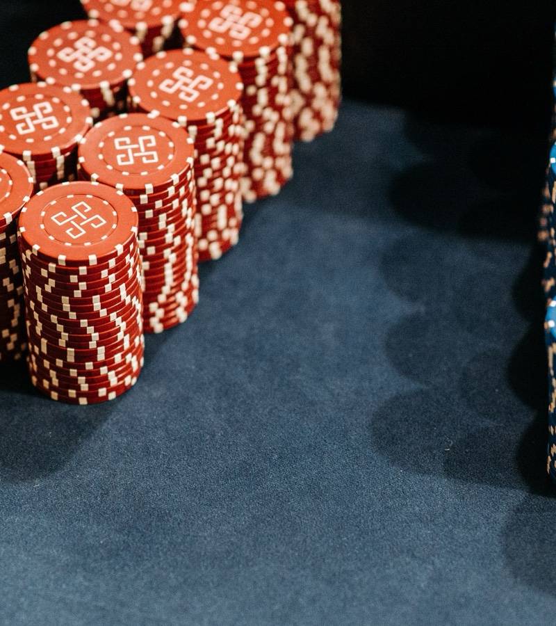 Tall stacks of red and blue casino chips standing on a dark green felt table.