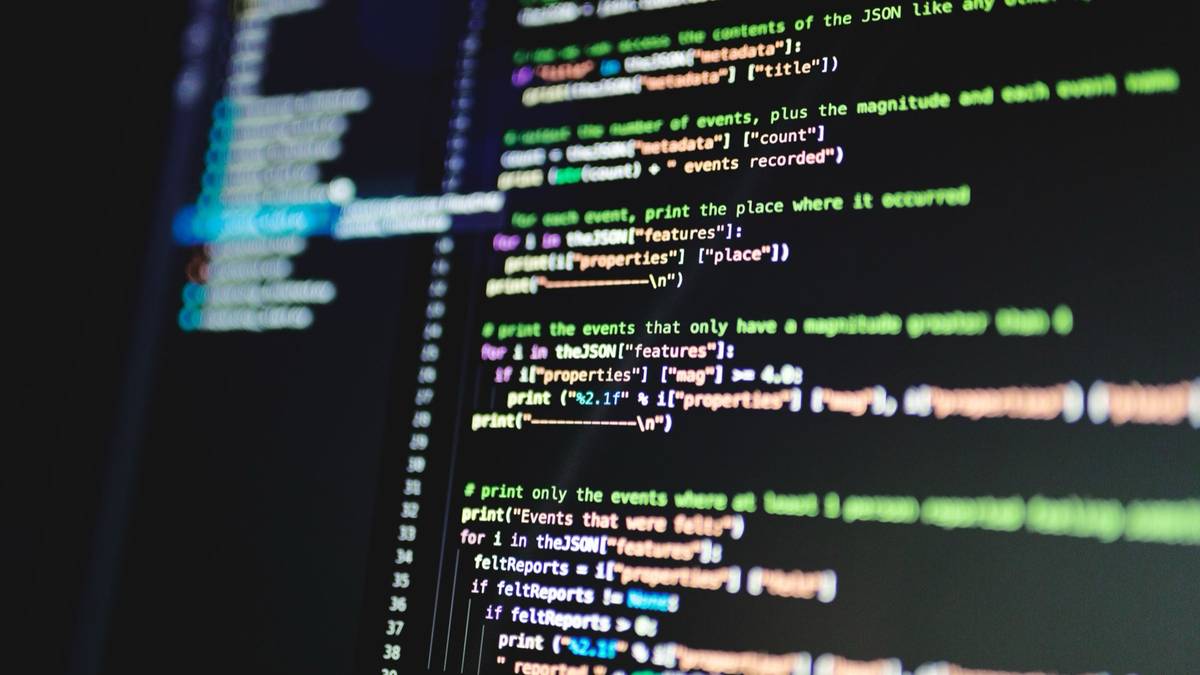 Lines of colourful program code on a dark monitor.