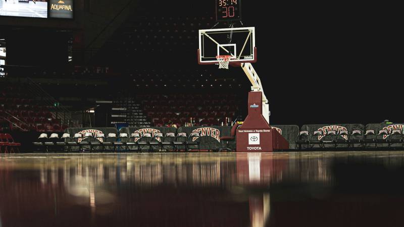 A basketball hoop and a shot clock over an empty arena floor before a game.