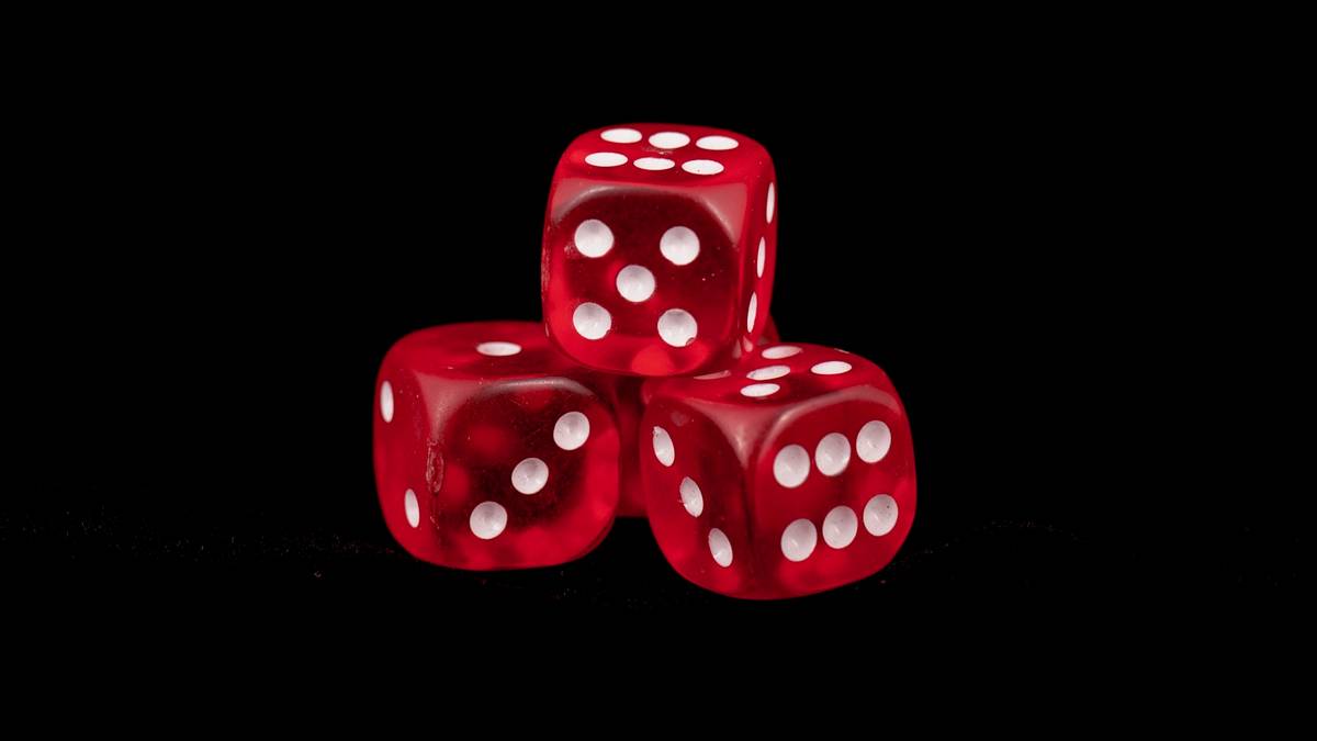 Three translucent red dice stacked against a black background